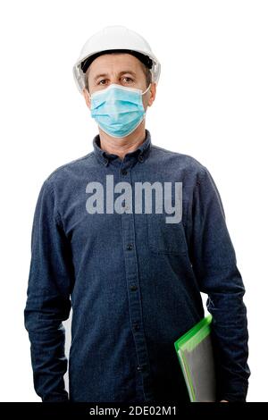Mittlerer Alter Auftragnehmer oder Architekt mit einem Notizblock, Tragen Schutzhelm und Gesichtsmaske Schutz gegen die Covid-19 oder Coronavirus isola Stockfoto