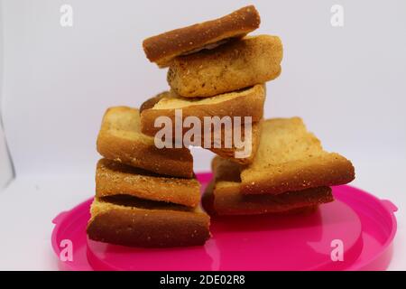 Stapel von trockenem Toast auf Kunststoffplatte. Nahaufnahme Stapel gerösteter Brotscheiben. Toastbrot auf weißem Hintergrund. Stockfoto