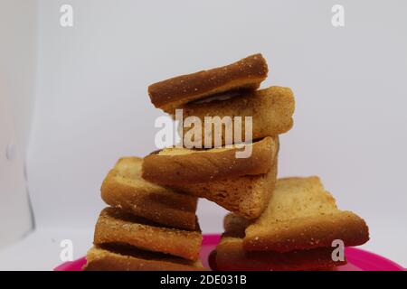 Stapel von trockenem Toast auf Kunststoffplatte. Nahaufnahme Stapel gerösteter Brotscheiben. Toastbrot auf weißem Hintergrund. Stockfoto