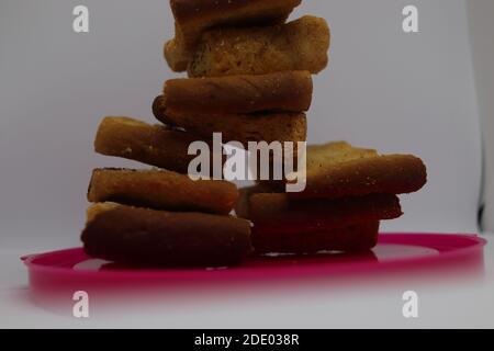 Stapel von trockenem Toast auf Kunststoffplatte. Nahaufnahme Stapel gerösteter Brotscheiben. Toastbrot auf weißem Hintergrund. Stockfoto