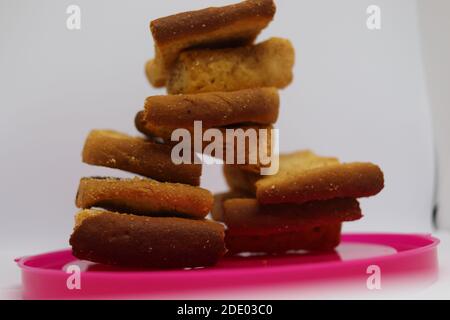 Stapel von trockenem Toast auf Kunststoffplatte. Nahaufnahme Stapel gerösteter Brotscheiben. Toastbrot auf weißem Hintergrund. Stockfoto