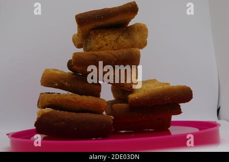 Stapel von trockenem Toast auf Kunststoffplatte. Nahaufnahme Stapel gerösteter Brotscheiben. Toastbrot auf weißem Hintergrund. Stockfoto