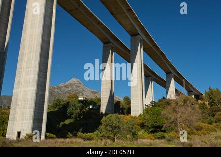 Eine massive Autobahnbrücke über das Rio Verde-Tal in Südandalusien, Spanien gegen einen klaren blauen Himmel Stockfoto