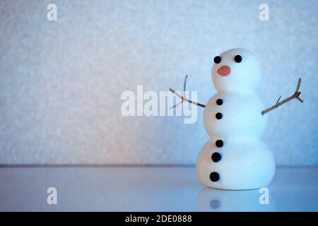 Kleine Schneemann Figur auf Winter gefrorene Landschaft mit Kopieplatz. Mockup, Kunstszene, Grußkarte, saisonaler Hintergrund. Stockfoto