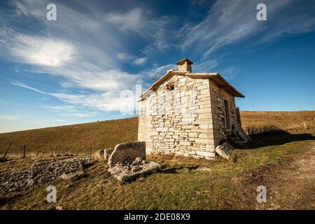 Kleines Bauernhaus aus Stein und Weiden im Herbst auf dem Plateau von Lessinia (Altopiano della Lessinia), regionaler Naturpark, Provinz Verona, Venetien, Italien, EU. Stockfoto