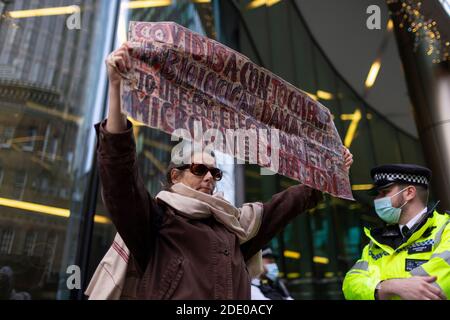 Protestler hält Banner während Anti-Impfprotest, Bill und Melinda Gates Foundation Office, London, 24. November 2020 Stockfoto