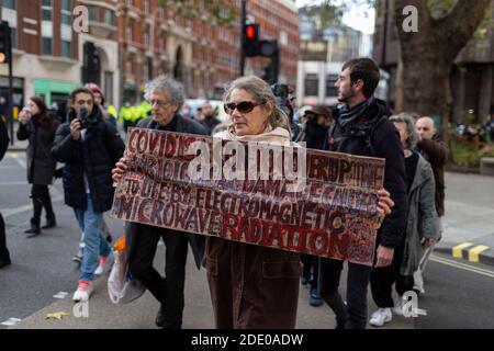 Protestierende marschieren mit einem Plakat während Anti-Impfprotest, Victoria, London, 24. November 2020 Stockfoto