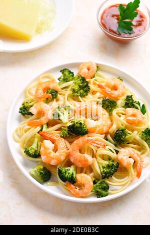 Garnelen und Brokkoli Pasta auf dem Teller über hellem Stein Hintergrund. Stockfoto
