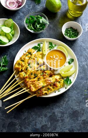 Hähnchen-Satay mit Erdnusssauce. Gegrillte Hähnchenspieße mit Erdnussdipping-Sauce. Leckeres Essen zum Abendessen oder Party Vorspeisen. Blaue Steinrückung Stockfoto