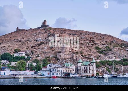 Sewastopol, Russland - 1. Oktober 2020: Blick auf den Stadtstrand Balaklava und den Berg Krepostnaya mit den Ruinen der mittelalterlichen genuesischen Festung Chembalo, Stockfoto