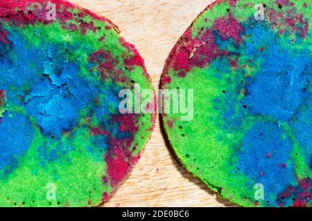Kochen süßen Biskuitkuchen zu Hause - Draufsicht auf Zwei bunte Schichten von gebackenem Kuchen Nahaufnahme auf Holz Brett in der heimischen Küche Stockfoto