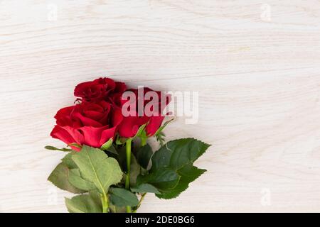 Bündel von roten Rosen auf Holzhintergrund liegen Stockfoto