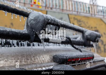 LED-Lampen auf dem Dach des Kofferraums eines SUV sind im Winter durch den Regen stark vereist. Stockfoto