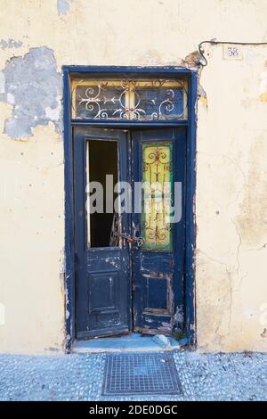 Alte verlassene blau bemalte Holztüren mit verzierten Eisenarbeiten an der Fassade des verlassenen Hauses, Altstadt von Rhodos, Rhodos, Griechenland Stockfoto