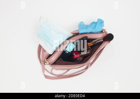 Damen Handtasche mit Kosmetik und medizinische Maske Desinfektionsmittel, covid-19, flach legen Stockfoto