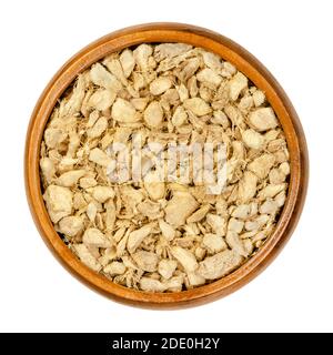 Ingwerwurzeln, geschnitten und getrocknet, in einer Holzschale. Stücke von trockenen Ingwer-Rhizomen, als wärmende Gewürztee und in der Volksmedizin verwendet. Zingiber officinale. Stockfoto