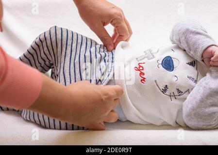 Mutter ändert eine Windel auf neugeborenem Baby Stockfoto