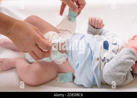 Mutter Wickelwindel adorable Baby mit einem Hygiene-Set Für Babys im Hintergrund Stockfoto