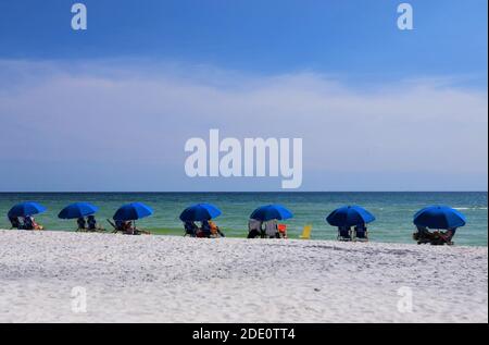 Urlauber am Strand sitzen unter Sonnenschirmen am Strand meer Stockfoto