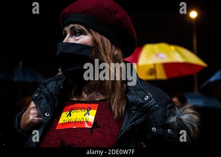 Madrid, Spanien. November 2020. Eine Frau, die eine Gesichtsmaske trägt, um sich vor der Ausbreitung des Coronavirus zu schützen, protestiert mit einem Aufkleber einer spanischen Flagge und der Aufschrift "Rücktritt der Regierung" während einer Demonstration gegen Zensur in sozialen Netzwerken vor dem Hauptsitz von Twitter. Quelle: Marcos del Mazo/Alamy Live News Stockfoto