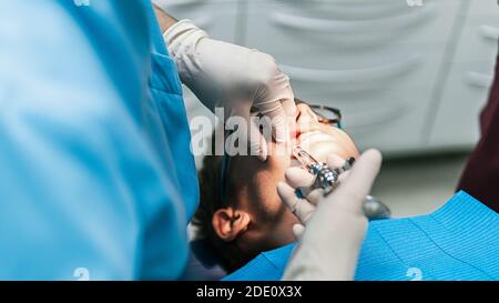 Stock Foto von nicht erkannten Zahnklinik Arbeiter mit Nadel, um Anästhesie zu jungen Patienten setzen. Stockfoto