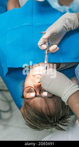 Stock Foto von nicht erkannten Zahnklinik Arbeiter mit Nadel, um Anästhesie zu jungen Patienten setzen. Stockfoto