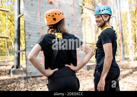Gut ausgerüsteter Mann und Frau, die draußen vor der Kletterwand stehen, bereit für das Klettern Stockfoto