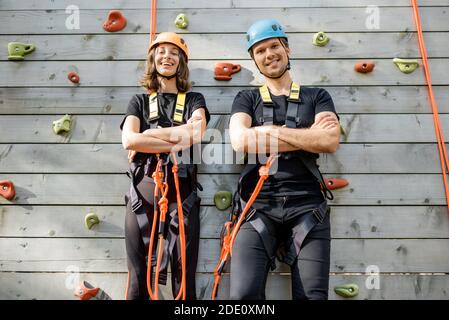 Porträt eines aktiven gut ausgestatteten Paar bereit, die zu klettern Wand am Vergnügungspark im Freien Stockfoto