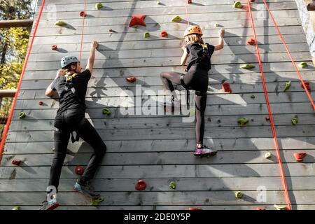 Gut ausgestattete Mann und Frau klettern die Wand im Freien in der park für sportliche Unterhaltung Stockfoto