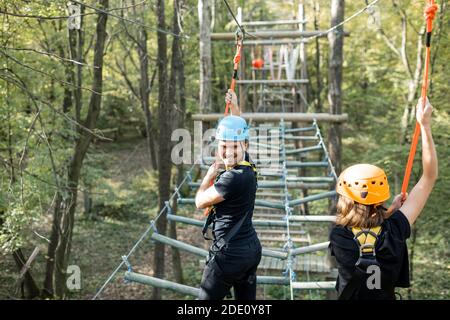 Gut ausgestattete Mann und Frau mit einer aktiven Erholung, Klettern Seile im Park mit Hindernissen im Freien Stockfoto