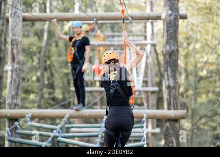 Gut ausgestattete Mann und Frau mit einer aktiven Erholung, Klettern Seile im Park mit Hindernissen im Freien Stockfoto