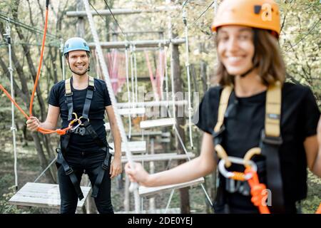 Gut ausgestattete Mann und Frau mit einer aktiven Erholung, Klettern Seile im Park mit Hindernissen im Freien Stockfoto