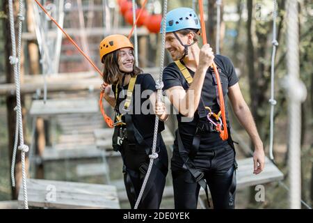 Portrait eines gut ausgestatteten Mannes und einer Frau mit einer aktiven Erholung, Klettern Seile im Park mit Hindernissen im Freien Stockfoto