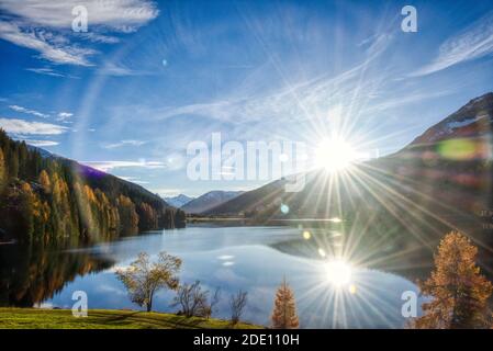 davosersee im Herbst. Schönes hintergrundbeleuchtetes Bild der schweizer Bergseenlandschaft Stockfoto