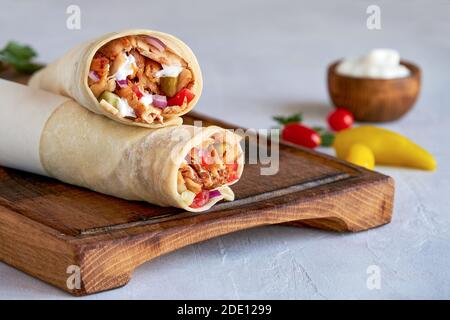 Shawarma mit Huhn und Knoblauchsauce auf Holzbrett. Nahaufnahme Stockfoto