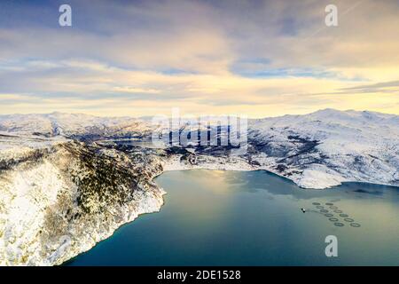 Luftaufnahme des bewölkten Himmels bei Sonnenuntergang über Fischfarmen und Bergen entlang Altafjord im Winter, Troms Og Finnmark, Nordnorwegen, Skandinavien, Europa Stockfoto