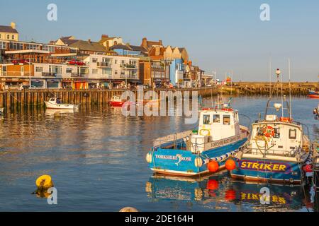 Blick auf Hafenboote und Hafengeschäfte in Bridlington Harbour bei Sonnenuntergang, Bridlington, East Yorkshire, England, Großbritannien, Europa Stockfoto