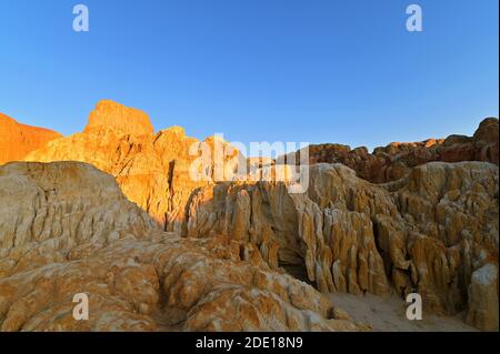 Der aufgehende Mond bei Sonnenuntergang, über den mehrfarbigen erodierten Felsformationen in Wucaitan, fünffarbiger Strand, Burqin County, Nord Xinjiang, China Stockfoto