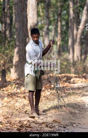 Ein Arbeiter räumt den Weg im Kahna-Nationalpark ein Indien Stockfoto