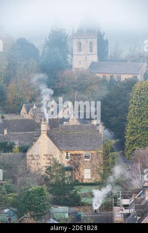 Frostiger nebliger Herbstmorgen bei Sonnenaufgang mit Blick auf Naunton. Cotswolds, Gloucestershire, England Stockfoto