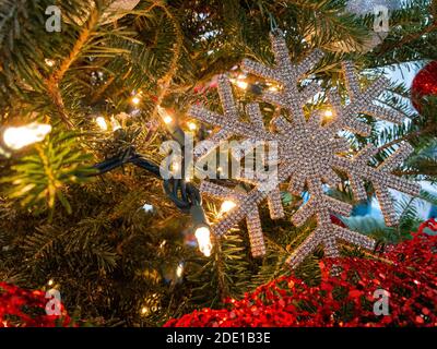 Nahaufnahme, Schneeflocke Dekoration auf einem Weihnachtsbaum von Lichtern umgeben Stockfoto