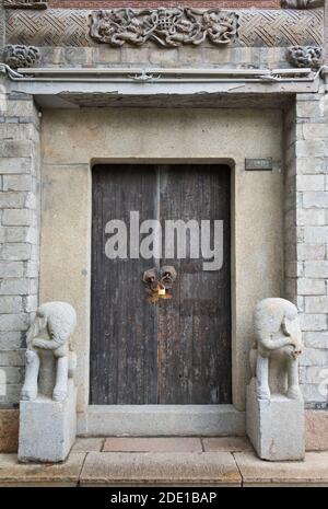 Steinstatuen an der Holztür eines traditionellen Hauses in der antiken Stadt Huishan, Wuxi, Provinz Jiangsu, China Stockfoto