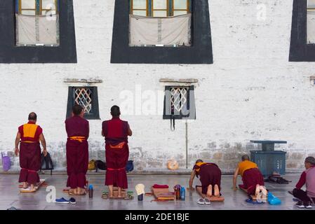 Mönche legen sich vor dem Jokhang-Tempel nieder, Teil des 'Historic Ensemble des Potala-Palastes und UNESCO-Weltkulturerbe, Lhasa, Stockfoto