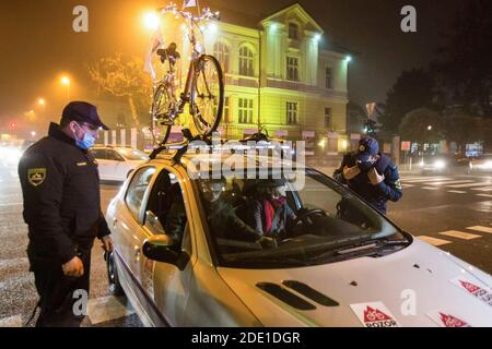 Polizeibeamte halten Demonstranten in einem Auto in der Nähe des slowenischen parlamentsgebäudes während eines regierungsfeindlichen Protestes an.die regierungsfeindlichen Proteste in der slowenischen Hauptstadt setzten sich fort, und Demonstranten, die zuvor Regierungsgebäude umherfuhren, fuhren jetzt mit ihren Autos, um die covid-19-Epidemie-Beschränkungen zu respektieren. Vor allem das Verbot von Versammlungen, die mit sehr hohen Geldstrafen belegt sind. Viele wurden dennoch von der Polizei gebucht und mit Geldstrafen belegt, was viele als einen Schritt einer anderen Regierung nehmen, um die Proteste zu kriminalisieren. Stockfoto