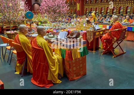 Buddhistische Mönche während der Morgengebete im Buddha Tooth Relic Tempel und Museum in Chinatown, Singapur Stockfoto