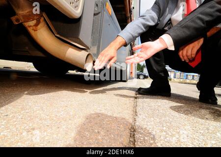 Luftverschmutzung durch LKW-Abgase, Hand am Auspuffrohr Stockfoto