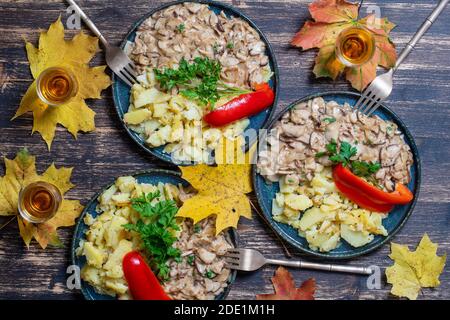 Geröstete Steinpilze und gebratene Kartoffeln auf dem Teller, Nahaufnahme, Draufsicht. Ukraine Stockfoto