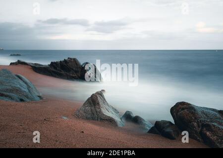 Schöne lange Exposition mit Felsen am Strand von Sant Pol de Mar, Katalonien, Spanien Stockfoto