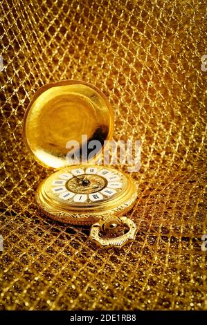 Alte gold Taschenuhr Verlegung auf Golden funkelnden Grid.. Stockfoto