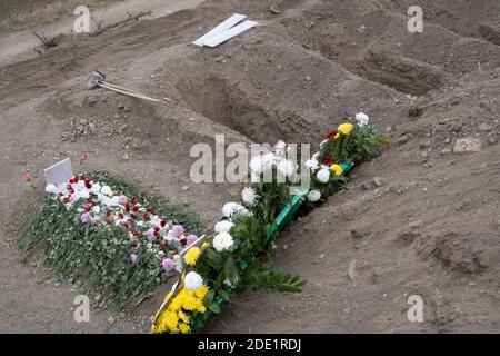 STEPANAKERT, BERG-KARABACH - 05. NOVEMBER: Blumen schmücken das Grab eines Dienstmanns, der während eines militärischen Konflikts zwischen armenischen und aserbaidschanischen Truppen auf einem Militärfriedhof in Stepanakert, der de facto Hauptstadt der selbsternannten Republik Arzakh oder Berg-Karabach, am 05. November 2020 getötet wurde. Die Kämpfe zwischen Armenien und Aserbaidschan um Berg-Karabach, auch bekannt als die Republik Arzakh, brachen Ende September in einen sechswöchigen Krieg mit beiden Ländern aus, die sich gegenseitig der Provokation beschuldigten, die Tausende Tote hinterließ. Stockfoto